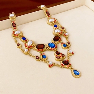 Dettaglio di collana di lusso con gemme colorate e perle in una scatola beige