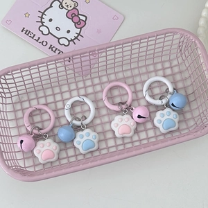 Cute pink and blue cat paw keychains with bells in a small pink decorative basket