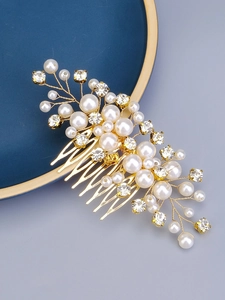 Detailed view of handcrafted gold bridal hair comb with elegant pearls and sparkling rhinestones