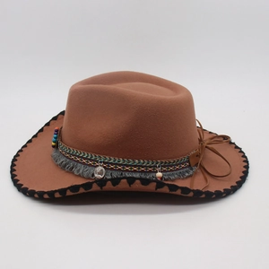 Detail of brown felt cowboy hat featuring colorful woven band and silver coin charm