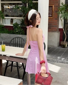 Detail of a pink striped halter dress with backless design and elastic waist for summer
