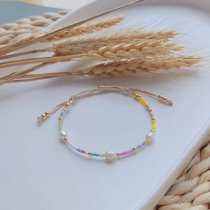 Detail of bohemian handmade beaded bracelet with freshwater pearls and colorful miyuki beads