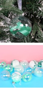Close-up of clear PET Christmas ornaments with ribbons and pearls on a snowy branch
