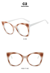 Detail view of cat eye frame glasses in white and brown tortoiseshell pattern