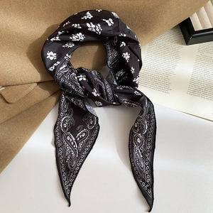 Detail of silk-texture neck scarf with vintage black and white paisley print on coat