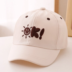 Detailed view of beige cotton kids baseball cap with sun embroidery and OK lettering