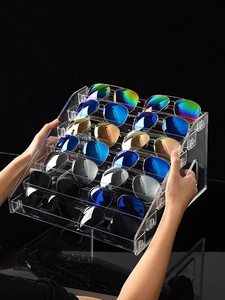 Detailed seven-tier transparent acrylic sunglasses display stand held by hands