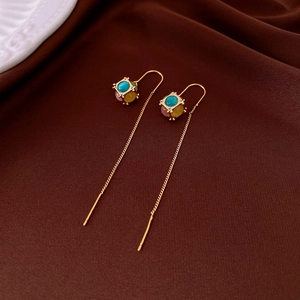 Detail of 18K gold-plated cube earrings with colorful gemstones and hanging chains