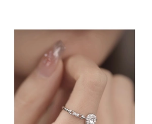 Detailed view of silver chain ring featuring a sparkling round diamond charm pendant