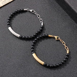 Detail of matte black onyx bead bracelets with gold and silver curved stainless steel tubes