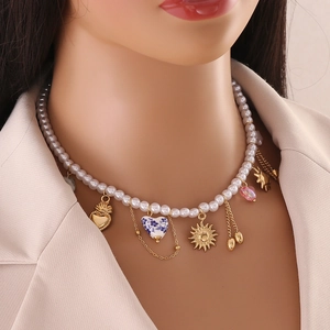Baroque pearl necklace with gold heart and sun pendants shown on a female model