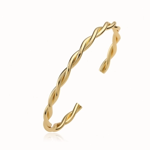Minimalist twisted gold plated copper bangle with elegant metallic luster on white background