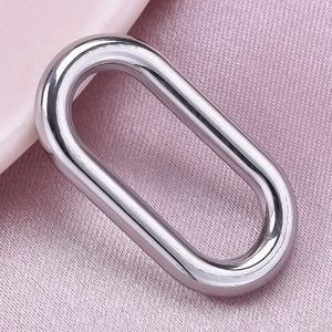 Macro shot of polished 304 stainless steel oval ring pendant on pink fabric background