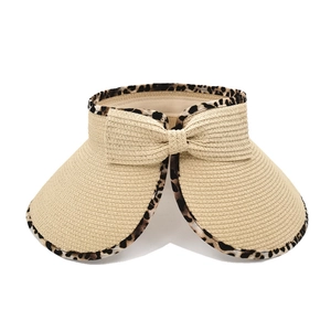 Detail of beige straw sun visor with leopard print trim and decorative bow ornament
