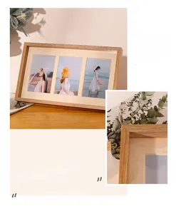 Detail of light oak triple photo frame with side metal clips on a wooden desk