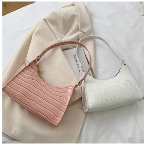 Close-up of pink and white baguette bags featuring realistic crocodile texture and hardware