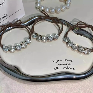 Close-up of sparkling rhinestone hair ties set on a white tray with elegant lighting