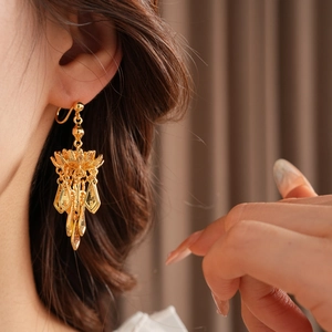 Detail of gold-plated lotus leaf fringe earrings with S925 silver needles on a model