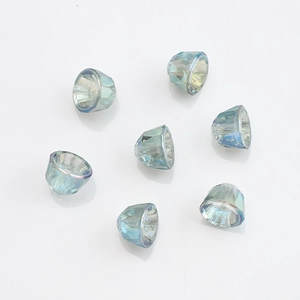 Macro shot of teal faceted crystal glass bell charms for DIY jewelry making and crafts