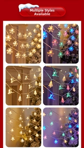 Detail view of festive LED string lights with snowflake, elk, and star shapes in warm light