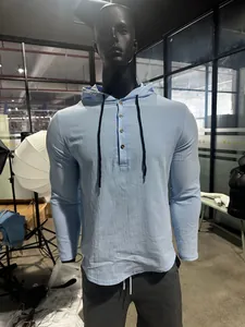 Detail of sky blue linen hooded Henley shirt with buttons and black drawstrings
