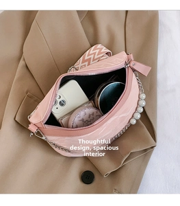 Pink patent leather half-moon bag interior view showing storage space for cosmetics