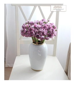 Close-up of vintage purple silk camellia bouquets in a gold-rimmed ceramic vase