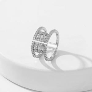 Macro detail of silver double-row ring with pave set cubic zirconia on white base