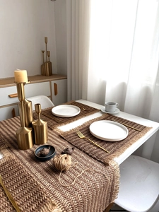 Close-up of rustic woven jute placemat with fringe details and natural texture