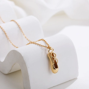 Elegante collar con colgante de zapatilla de ballet en oro de 18K sobre fondo geométrico