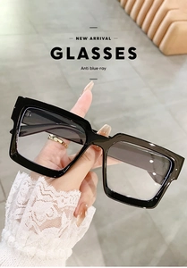 Detail of glossy black square anti-blue light glasses worn in a lifestyle setting