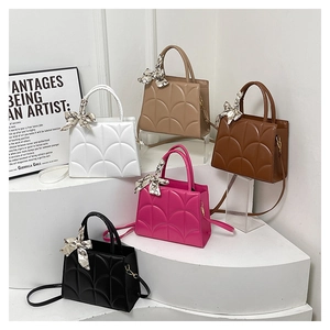 Detalle de bolsos tote acolchados en cinco colores con pañuelos de seda decorativos en asas