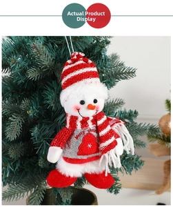 Plush Christmas snowman ornament with Merry Christmas sweater hanging on a festive tree