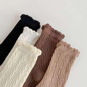 Five pairs of cable knit mid-calf socks with ruffle trim in various brown and cream colors
