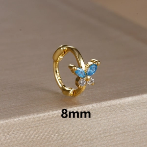 Detailed macro view of 8mm golden butterfly hoop earring with blue and clear zircon