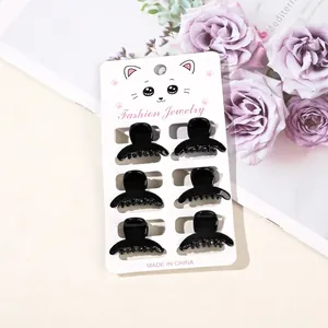 Set of 6 mini glossy black hair claw clips displayed on a white cat card holder