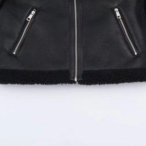 Black leather jacket with shearling hem and metallic zipper details in close-up view