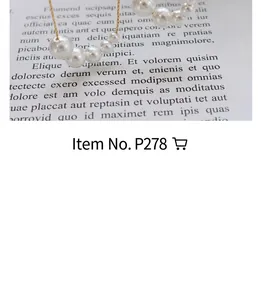 Detailed view of an elegant gold chain necklace with lustrous white pearls on white paper