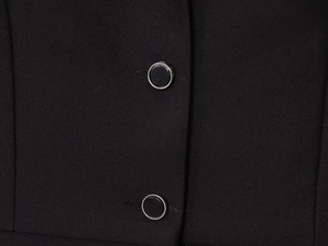 Detail der Twill-Stoffstruktur und schwarzen Knöpfe mit Silberrand an einer Weste