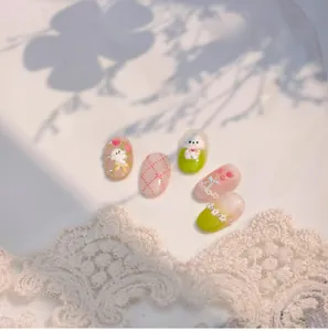 Détail d'ongles à presser fleuris avec lapin 3D, perles et motifs à carreaux roses