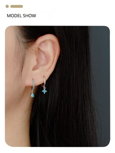 Detail of silver clover and teardrop earrings with turquoise stones on a model