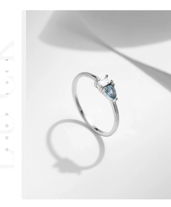 Macro detail of 925 sterling silver ring with drop-shaped blue stone and rectangular zircon
