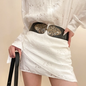 Détail d'une ceinture élastique vintage avec boucle fleurie dorée filigranée