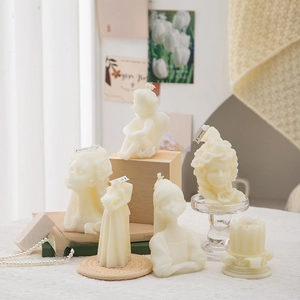 Artistic cream-white portrait sculpture scented candles on elegant lace tablecloth