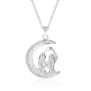 Detailed view of silver crescent moon necklace with Celtic knot and figures forming a heart