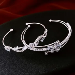 Silver-tone layered open bangles with zircon butterflies and floral accents on black stand