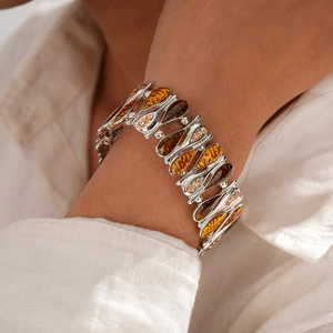 Dettaglio del bracciale a catena color argento con zircone ambrato a goccia d'acqua