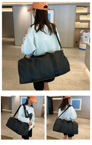 Black travel gym bag shown being worn by a model to display large capacity and size