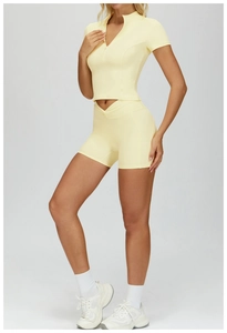 Detail view of pale yellow yoga set with half-zip stand collar top and high-waist shorts