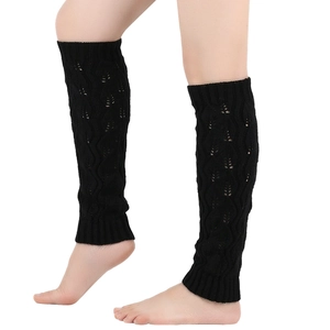 Detail of black knit leg warmers with hollow leaf pattern worn over black boots